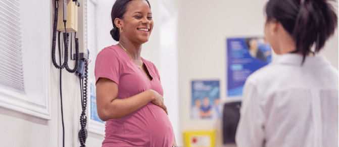 Smiling pregnant woman has a conversation with her healthcare provider