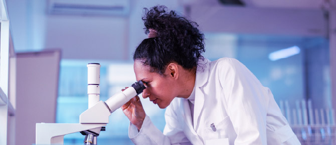 Clinician looking through microscope