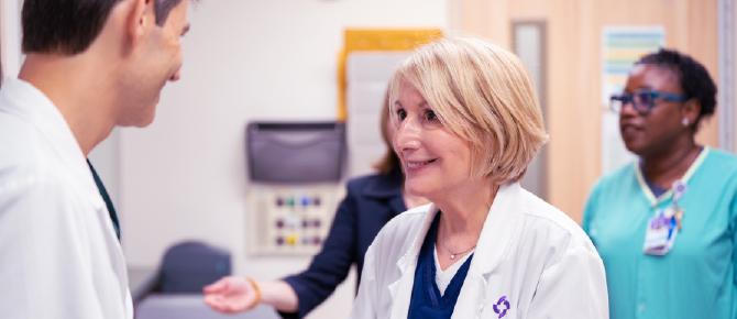 Photo of Wellstar CEO Candice L. Saunders speaking with a colleague