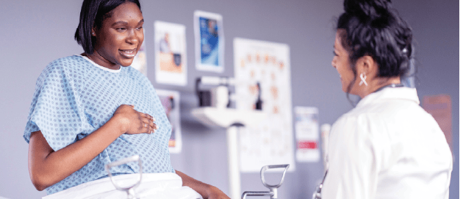 An OB/GYN healthcare provider reassures her patient during a medical examination