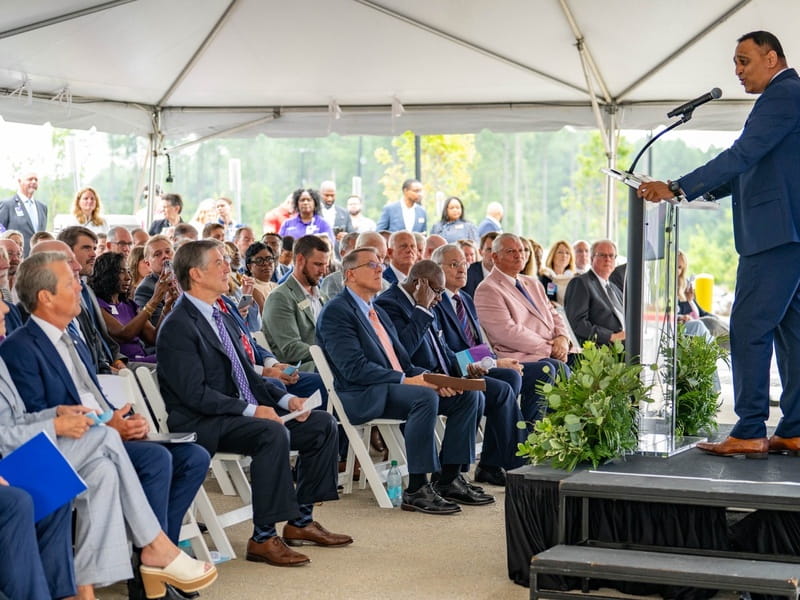 Image of CEO addressing crowd at ribbon cutting 