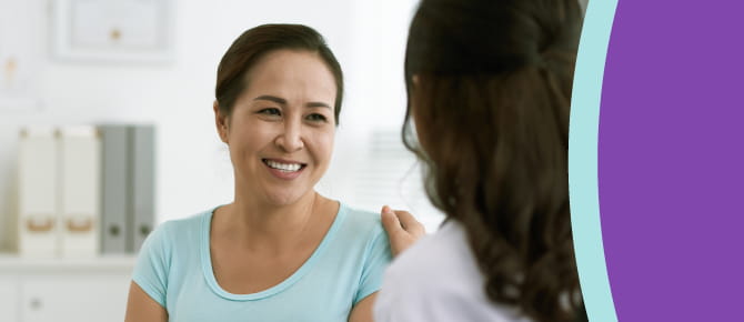 A woman's healthcare provider consults with her, placing a comforting hand on her shoulder