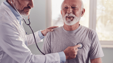 Healthcare provider checks the heart of his smiling patient with a stethoscope