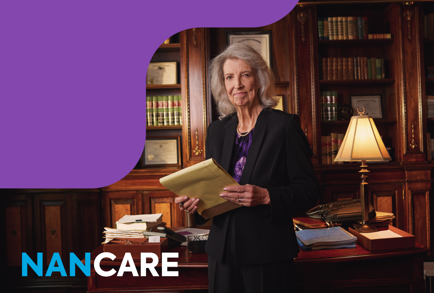 Nan in her office smiling with notebook