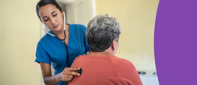 A healthcare provider checks the lungs of her patient using a stethoscope.