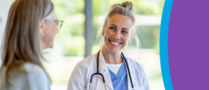 Smiling healthcare provider consults with her patient while holding a clipboard