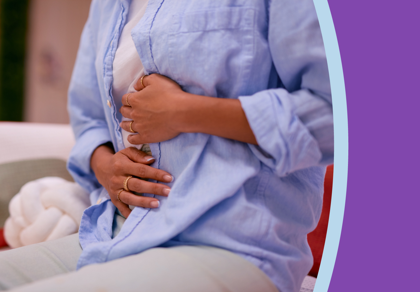 A woman holds both hands to her stomach in pain