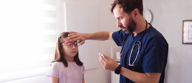 Healthcare provider checks girl's temperature
