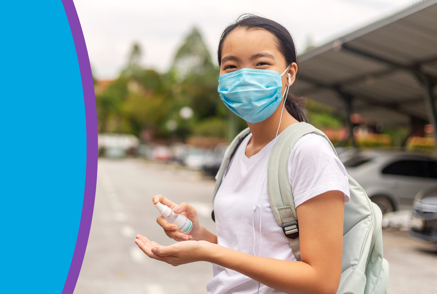 College student wearing mask and using hand sanitizer.