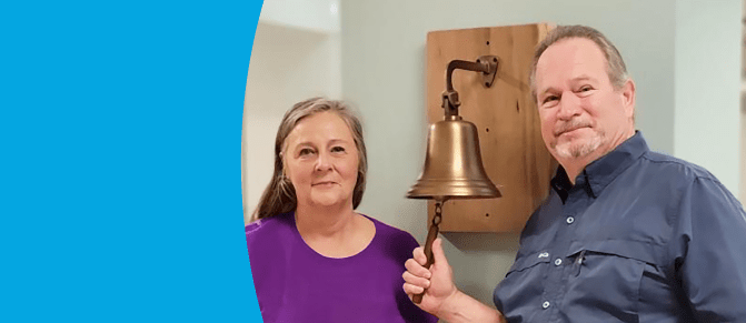 Greg Rodgers with his wife ringing the cancer bell