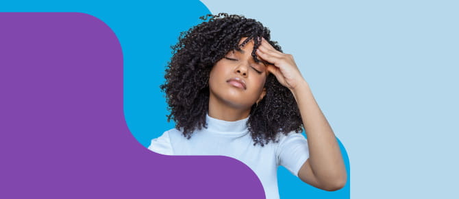 Woman with headache holds her hand to her forehead