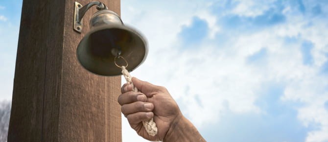 Hand ringing bell in celebration of conquering cancer