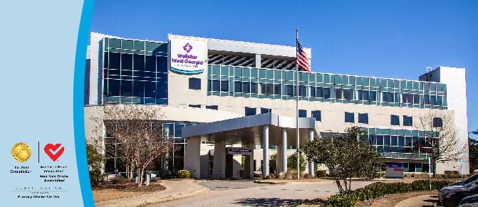 Exterior photo of Wellstar West Georgia Medical Center. The Joint Commission and American Heart Association/American Stroke Association logos. Text reads "Certification, Primary Stroke Center"