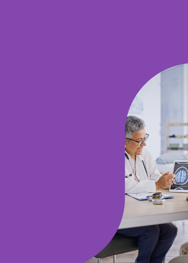 Healthcare provider uses an image of a brain on a tablet to discuss treatment with a patient