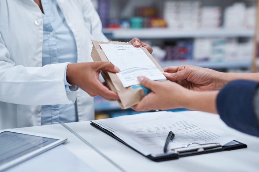 Pharmacist giving customer their prescription