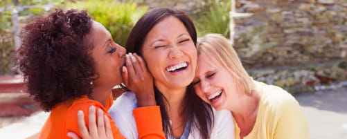 women whispering and laughing
