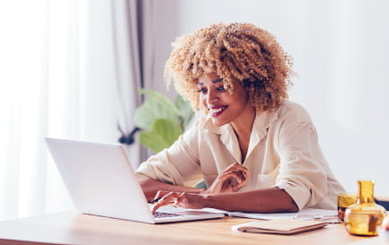 Smiling woman using her laptop computer