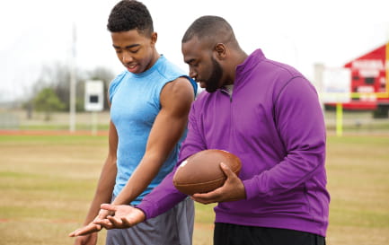 Football coach speaking to his student