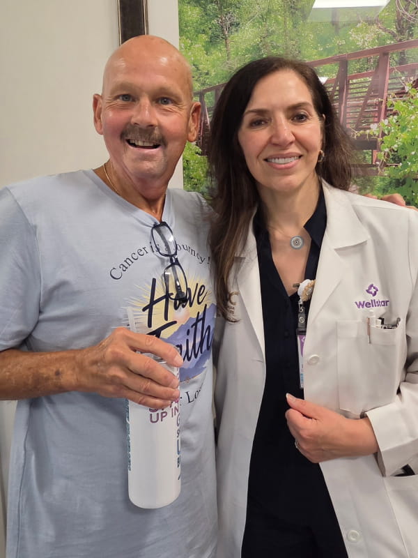 David Butler stands, smiling, with Dr. Ghada Kunter, his medical oncologist at Wellstar Holly Springs Health Park.